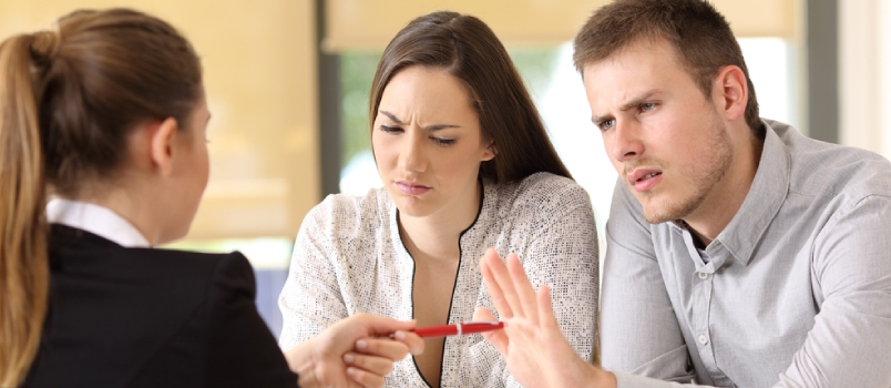 Saleswoman Offering A Pen To A Couple Of Angry Customers That Rejects To Sing A Contract At Office