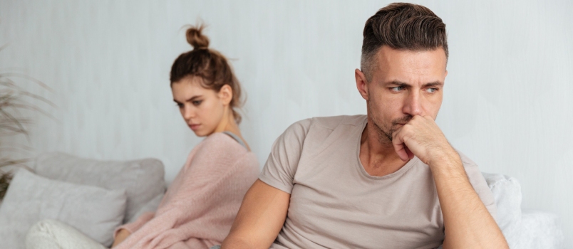 Young Couple After Fighting Sitting Apart At The Living Room On The Sofa Or Bed