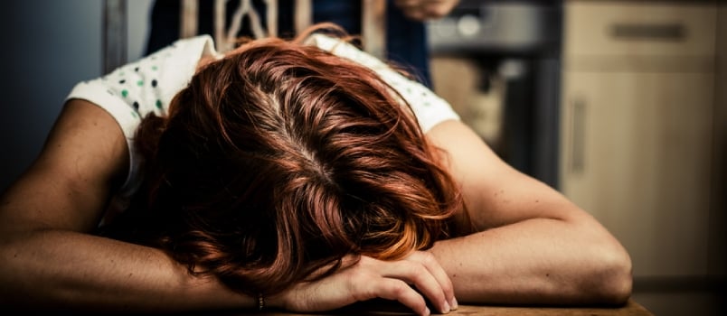 Crying Woman With Abusive Partner Behind Her