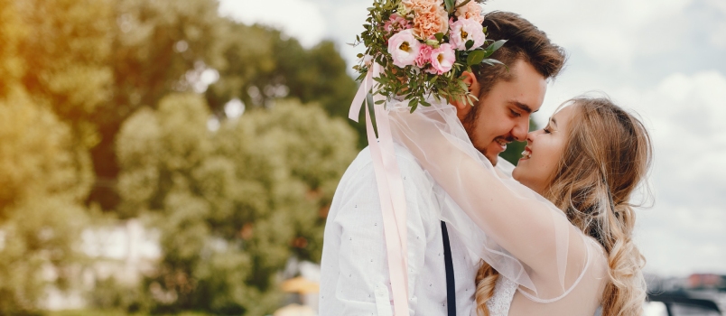 Beautiful Bride With Her Husband Park Holding Flowers In The Hand In Kissing Pose