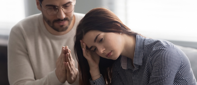 Head Shot Close Up Upset Abused Offended Woman Sitting on Sofa, Ignoring Her Apologizing Husband
