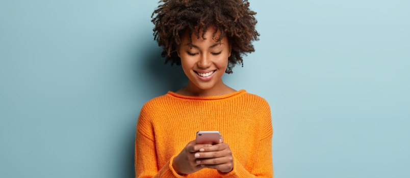 Girl Texting on Mobile Phone Smiling in the Yellow Dress