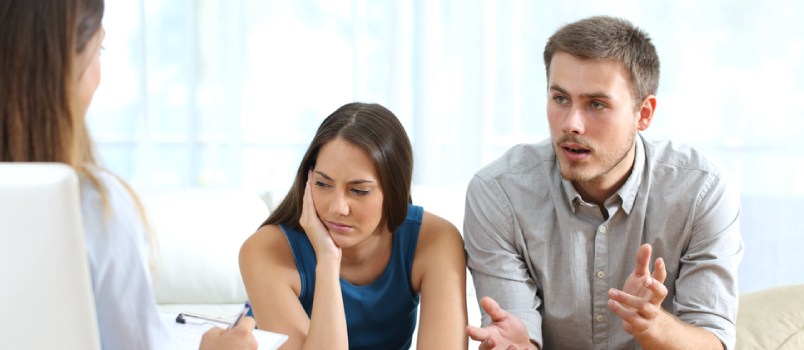 unhappy couple sitting in a therapy session trying to sort out their issues