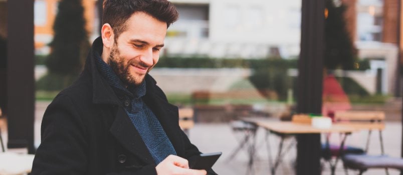 Young man texting in the cafe