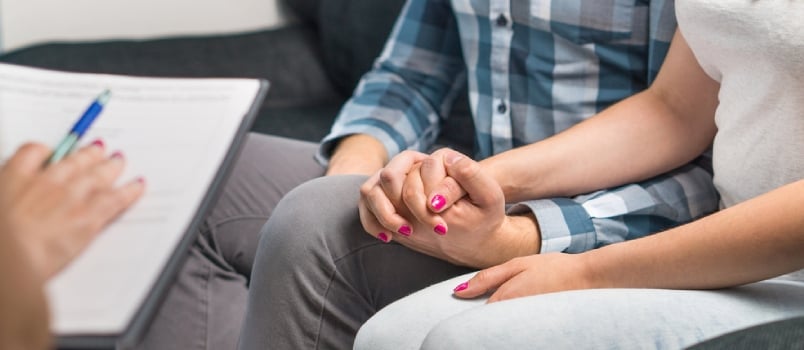 Man and Woman Holding Hands on Couch During a Psychotherapy Session