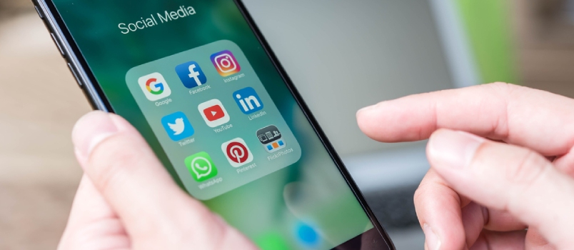 Hand Of Man Using Iphone7 Plus With Icons Of Social Media On Screen