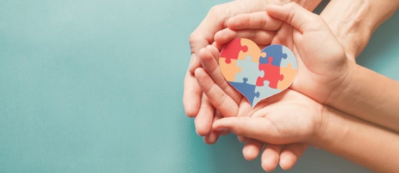 Adult and Chiild Hands Holding Jigsaw Puzzle Heart Shape, Autism Awareness