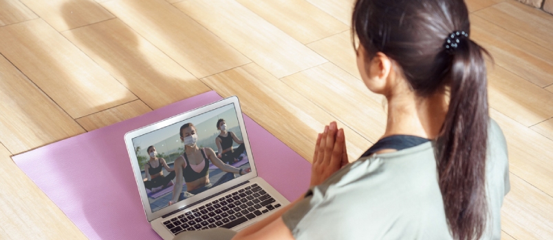 Young Woman Meditating Watching Live Online Tv Pilates Group Class Tutorial on Laptop Computer at Home Doing Yoga Virtual Training