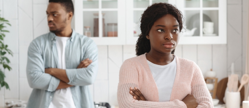 Young African American Spouses Ignoring Each Other After Argue, Offended Black Man and Woman Standing With Folded Arms in Kitchen