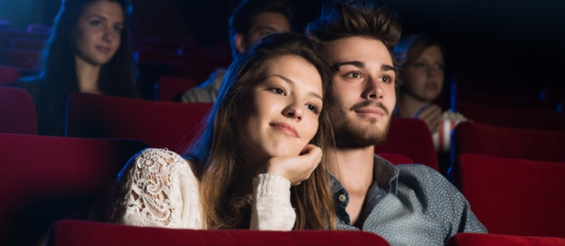 Young Loving Couple at the Cinema Watching a Movie, He Is Hugging Her Girlfriend