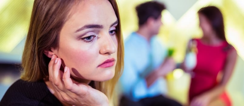 Sad Woman Against Couple at Nightclub