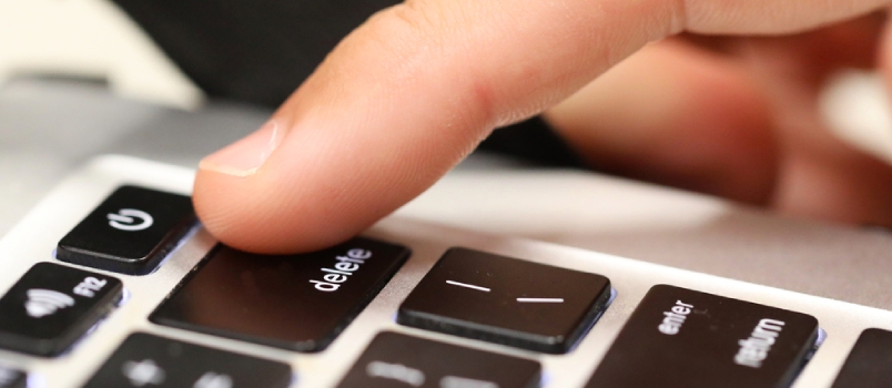 A Close Up of a Finger About to Push the Delete Key on a Computer Keyboard Deleting History, Cancel Culture Idea