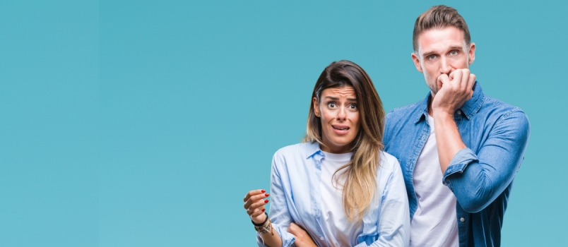 Young Couple in Love Over Isolated Background Looking Stressed and Nervous With Hands on Mouth Biting Nails