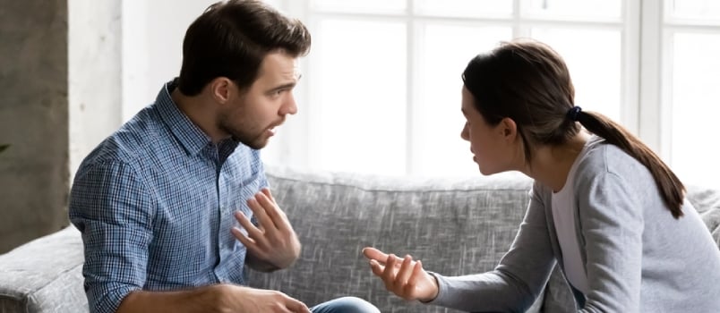 Stressed Young Married Family Couple Arguing Emotionally, Blaming Lecturing Each Other, Sitting on Couch