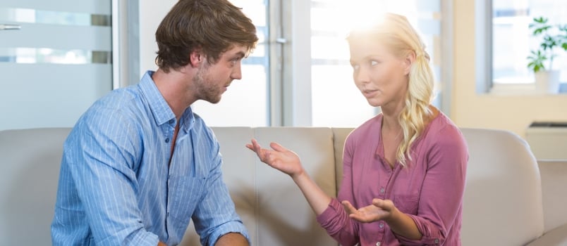 Unsmiling Couple Talking to Each Other in the Therapist Office