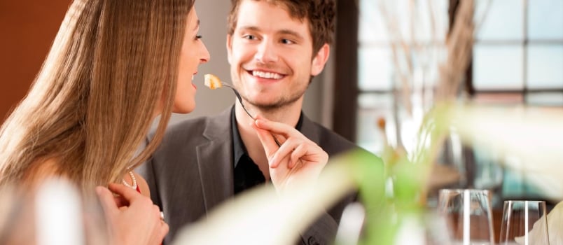 Cheerful Man Feeding His Girlfriend at Hotel on a Special Occasion