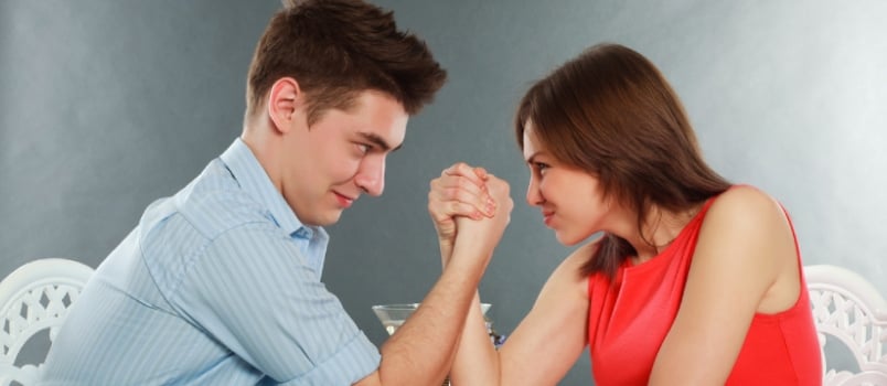 Young Happy Couple Challenge Fighting in Arm-wrestling at Table, in Studio