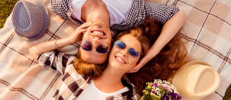 Pretty Women and Men on Picnic Lying on Bedsheet and Looking on Camera