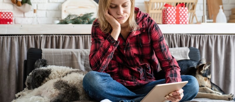 Young Sad Woman in Working on Tablet Sitting on the Couch