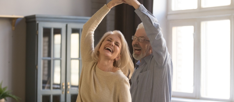 Overjoyed Mature Grey-haired Caucasian Husband and Wife Have Fun Enjoy Time Together at Home