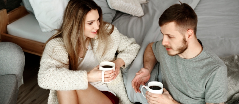 Couple With Coffee Sitting on Floor and Talking