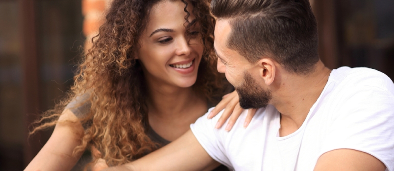 Happy Loving Couple Using a Smartphone Sitting in Terrace