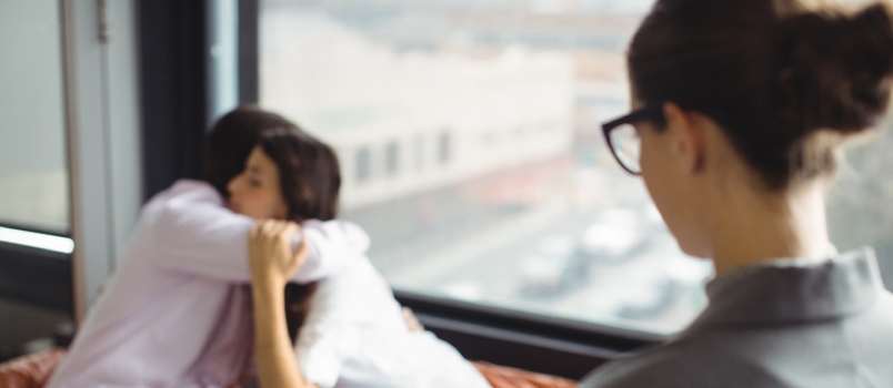 Couple Embracing Each Other in Front of Marriage Counselor During Therapy