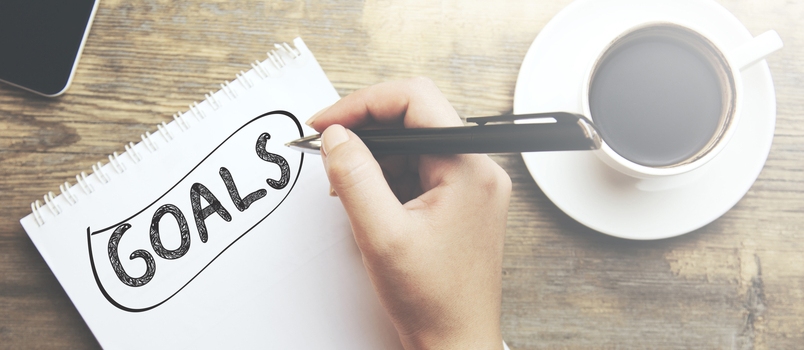 Goals Memo Written on a Notebook With Woman Hand Pen