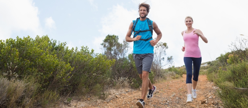 Fit Attractive Couple Jogging Down Mountain Trail on a Sunny Day