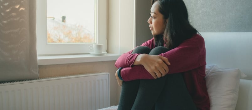 Asian Woman Is Sitting on the Bed Looking Out to the Windows and Thinking or Missing of Someone.