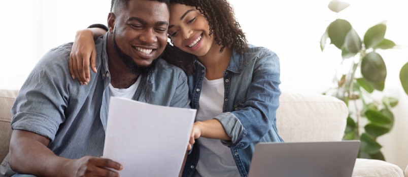 Positive Black Couple Reading Documentation at Home, Checking Agreement Details Together