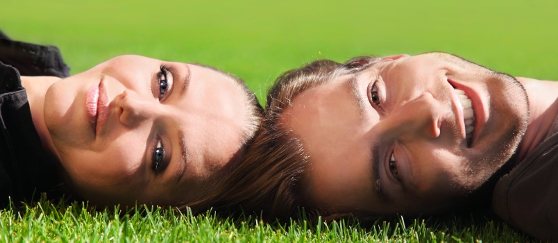 Closeup Portrait of a Happy Laughing Couple Lying on the Grass