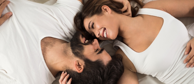 High Angle View of Smiling Couple Relaxing and Lying Down in Bed .they Are Looking at Each Other