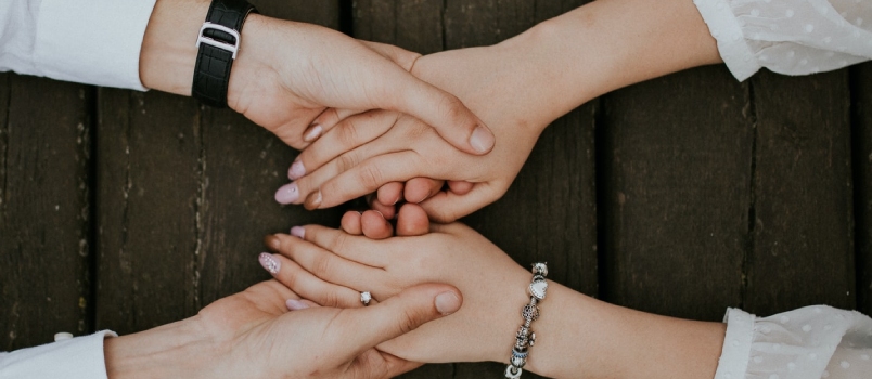 Closeup Top Short Men and Women Holding Their Hands Together and Wooden Table
