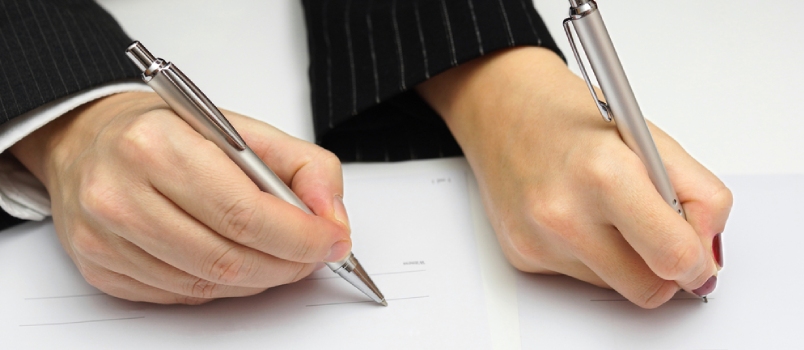 Man and Woman Signing Document or Prenuptial Agreement