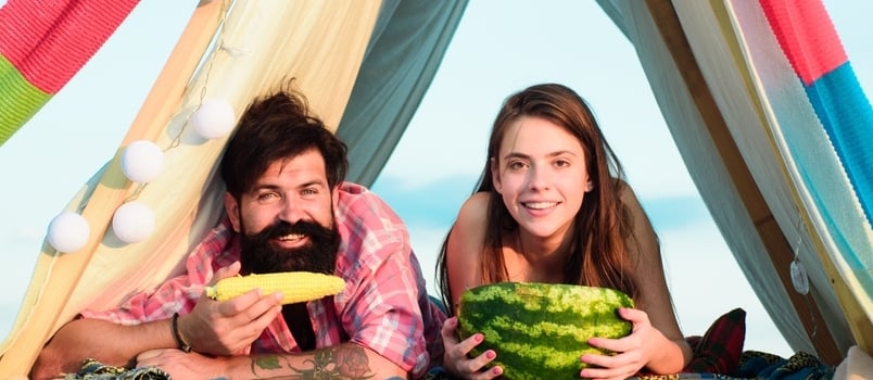 Camping Lovers. Romantic Couple Eating Watermelon and Corn.