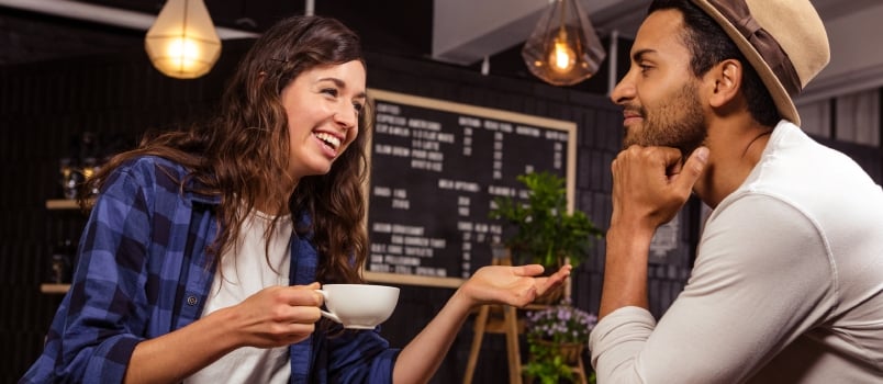Couple Talking and Drinking Coffee in a Coffee Shop