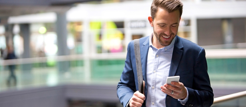 View of a Young Attractive Business Man Using Smartphone