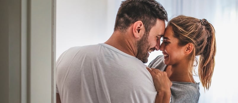 Handsome Man in White T-shirt Carrying Young Attractive Woman While Spending Free Time at Home