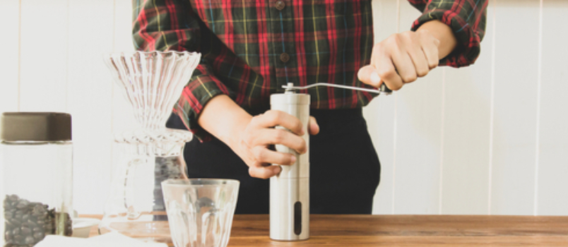 Barista Is Grinding Coffee Beans With Manual Stainless Steel Grinder to Make Black Coffee Machine