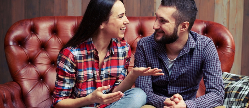 Smiley Couple Sitting on Couch and Have a Nice Conversation at Home