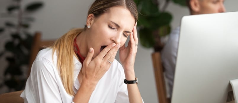Bored Businesswoman Yawning at Workplace Feeling No Motivation or Lack of Sleep