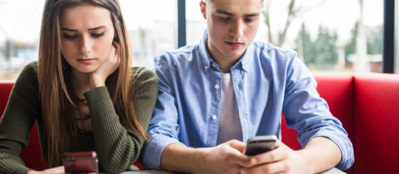 Young Couple in Cafe Looking at Their Smartphones, Social Network Concept