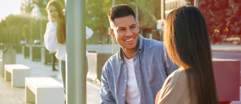 Young Woman Spying on Her Boyfriend Outdoors. Cheating Concept