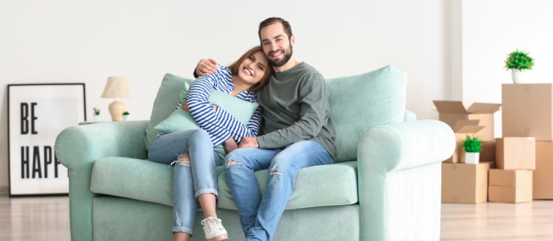Young Couple Sitting on Sofa After Moving to New Home