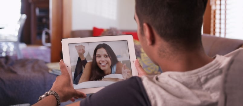 Millennial Man Video Chatting or Having a Facetime Conversation With His Girlfriend on Tablet Computer