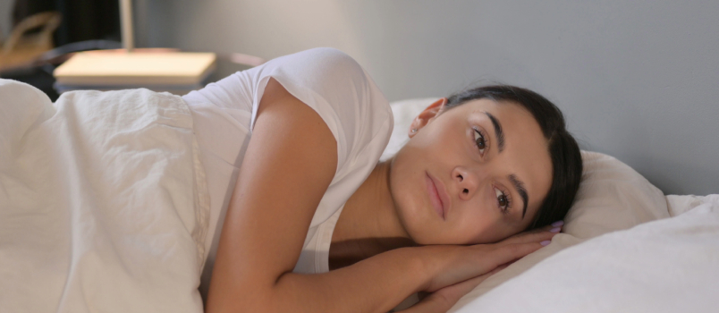 depressed woman laying on bed