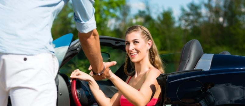 Young hip couple - man and woman - with cabriolet convertible car in summer on a day trip