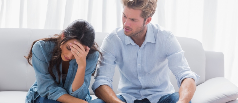 Worried couple doing their accounts in the living room