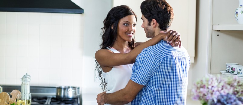 men and women in a romantic mood at kitchen enjoying themselves